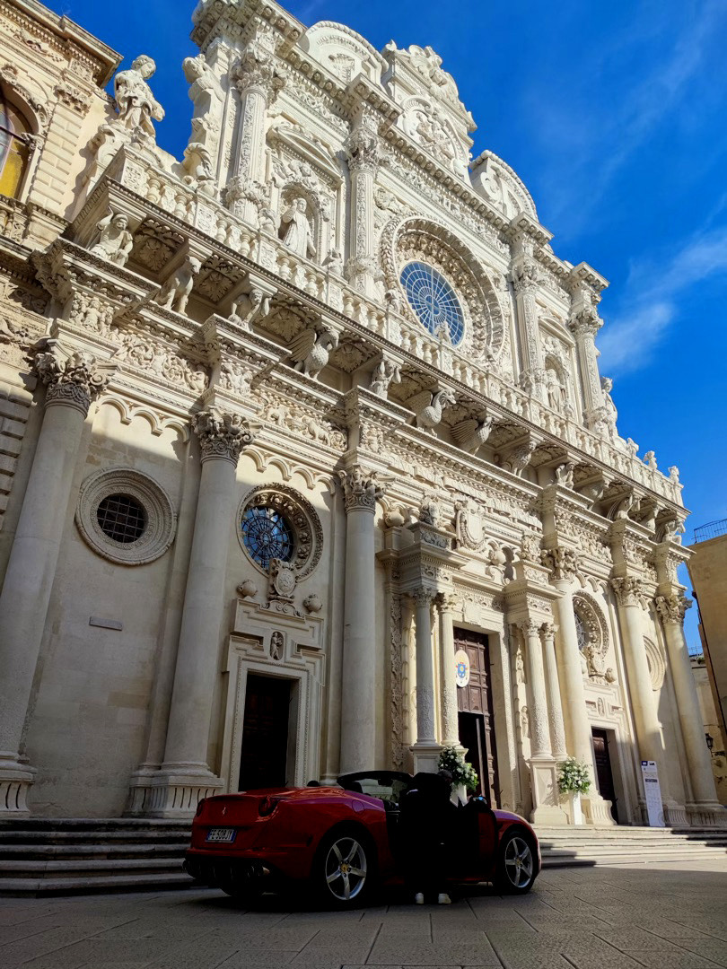 Auto rossa parcheggiata davanti a una chiesa