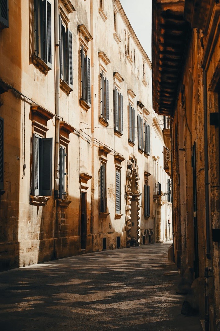 Vicolo di pietra con persiane chiuse